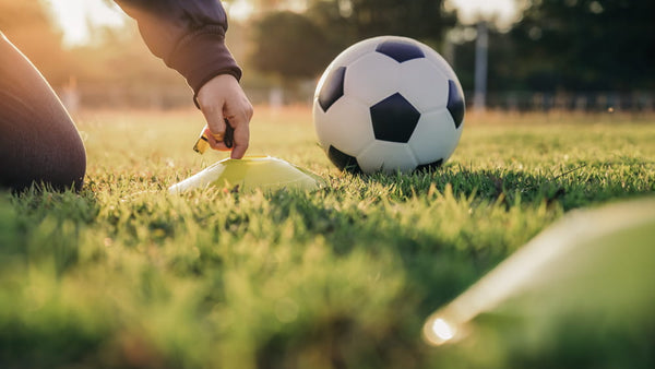 Person preparing to kick a soccer ball on a grass field. Showcasing our amenity lawn seed, grass lawn seed, lawn grass seed, garden grass seed, seed mixtures, amenity grass, sport grass seed, grass seed on football pitch, football pitch grass, golf greens, golf course grass seed